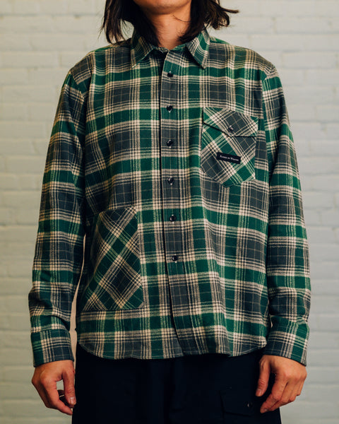 Front of long red sleeve red plaid shirt. Chest pocket has Raised By Wolves logo and the bottom has the cargo pocket. 