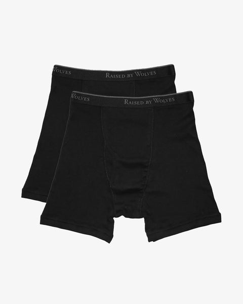 Two pairs of white cotton boxer briefs with a black band and Raised By Wolves printed in grey around the band.
