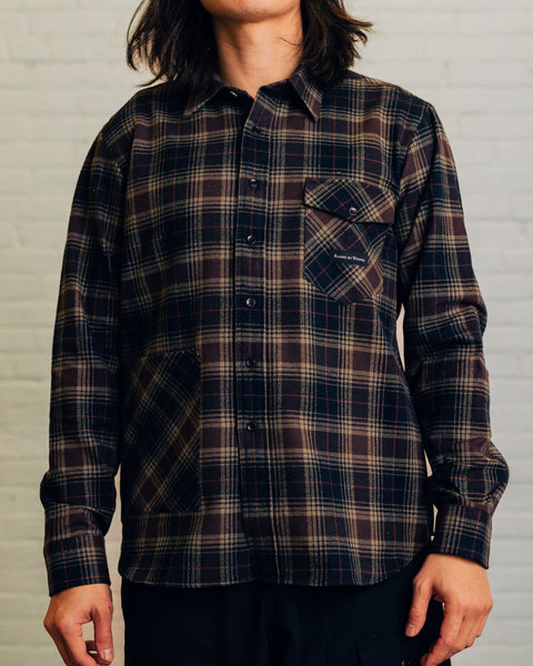 Front of long red sleeve red plaid shirt. Chest pocket has Raised By Wolves logo and the bottom has the cargo pocket. 