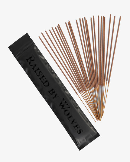 Black Raised By Wolves package for sealing and storing, with the 25 incense sticks fanned out beside it. 